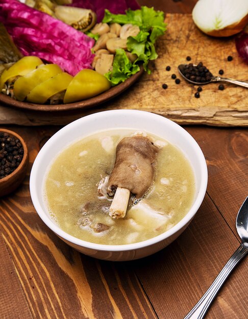 Manzo, zuppa di brodo di agnello con un pezzo di carne, salsa di pomodoro e cipolle, sumakh.