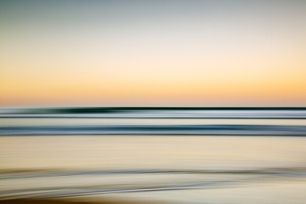 Mare durante un tramonto colorato con un effetto di movimento: una bella immagine per sfondi e sfondi