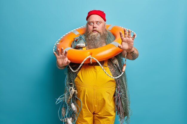Marinaio maschio barbuto obeso con rete da pesca