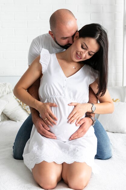 Marito che abbraccia la moglie incinta