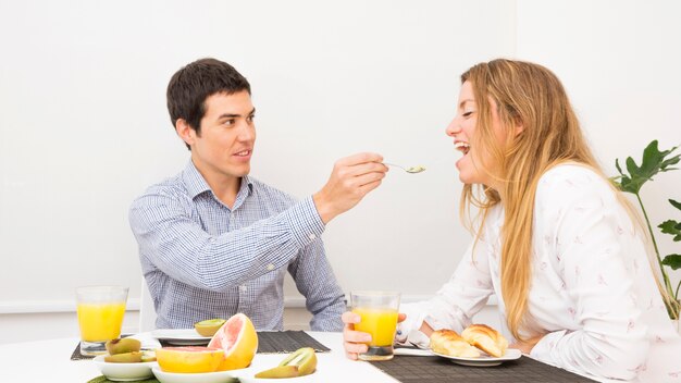 Marito che alimenta il cibo alla sua ragazza facendo colazione