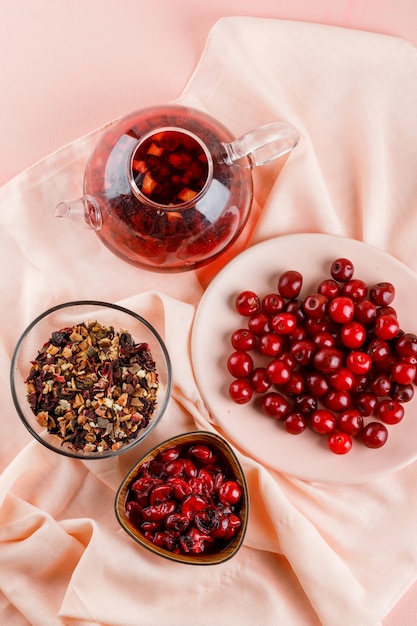 Marmellata di amarene con ciliegie, tè, erbe secche in una ciotola su tessuto e rosa