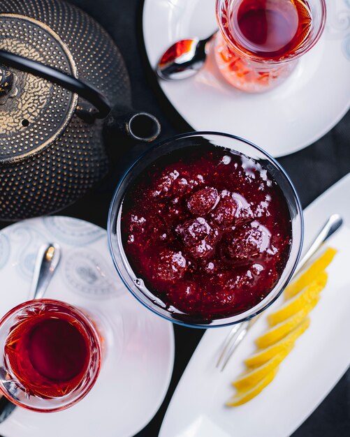 Marmellata di fragole con teiera di tè e vista superiore di vetro armudy