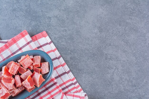 Marmellata rossa affettata in un piatto sul canovaccio, sulla superficie di marmo marble