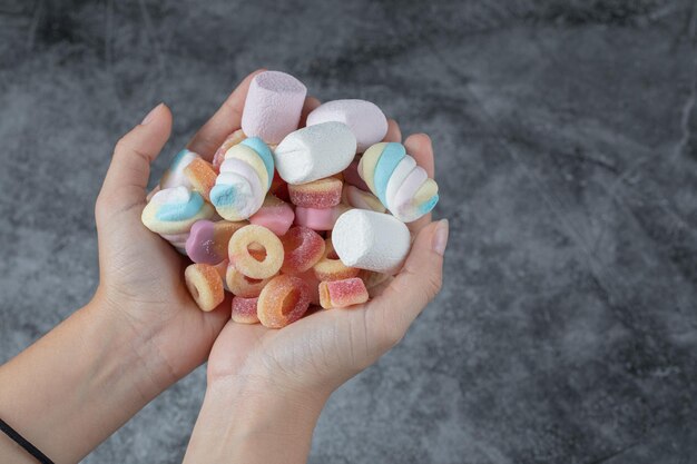 Marshmallow e gelatine di forma mista a portata di mano.