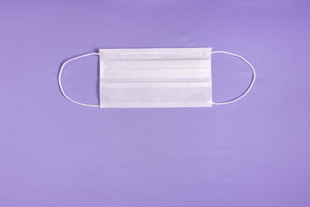 Maschera chirurgica su sfondo viola minimalista