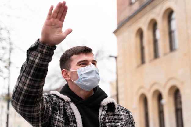 Maschera da portare dell'uomo di vista bassa che fluttua con la mano