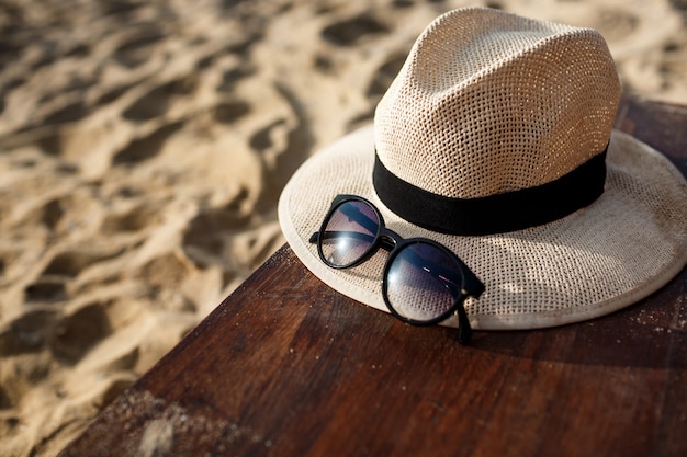 Maschera del primo piano del cappello e dei vetri sulla spiaggia