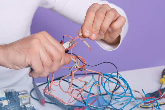 Maschera dell'interno del primo piano delle mani dell'uomo che tengono i pilastri e i conduttori di taglio laterali, facendo il suo lavoro nel modo giusto, facendo riparazione da solo