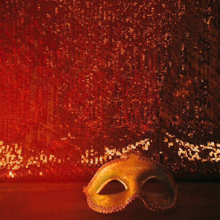 Foto gratuito maschera di carnevale lucido contro tessuto tessile scintillante rosso