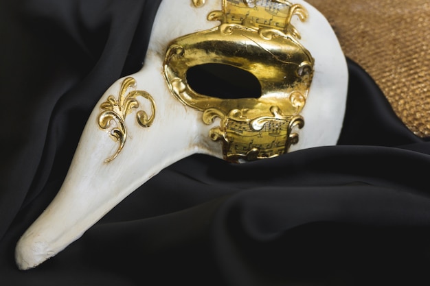 maschera veneziana con un lungo naso su un panno scuro
