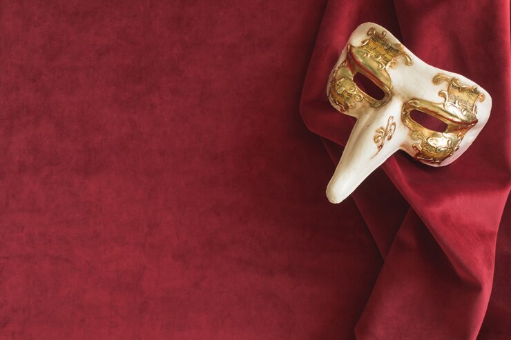 Foto gratuito maschera veneziana con un lungo naso su un tessuto rosso