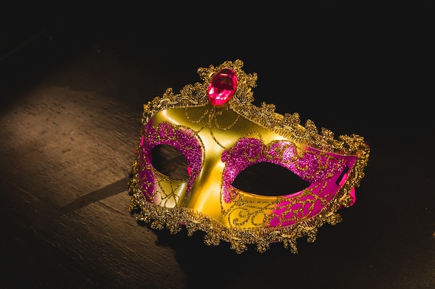 maschera veneziana dorata su un tavolo di legno