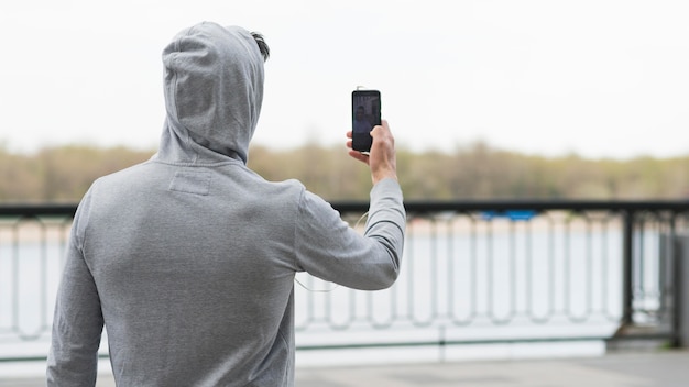 Maschio adulto di vista posteriore che prende una foto