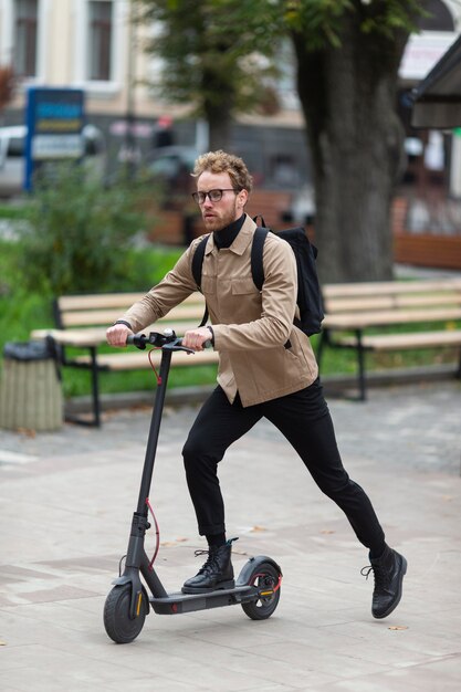 Maschio casuale in sella a uno scooter elettrico