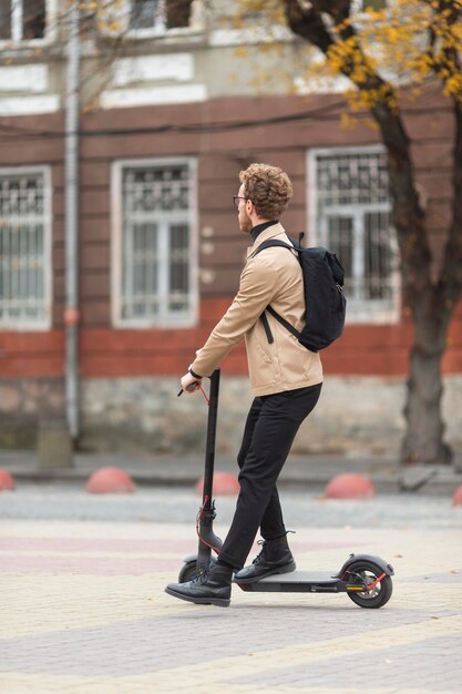 Maschio casuale in sella a uno scooter elettrico
