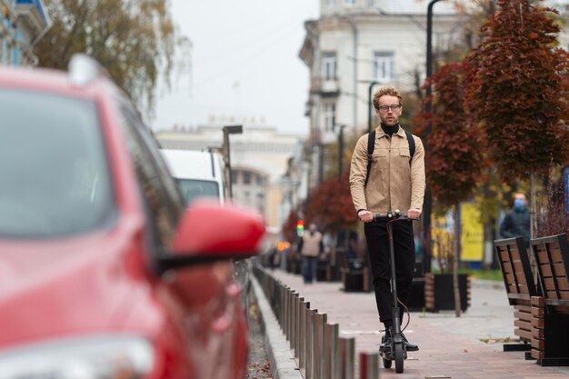 Maschio casuale in sella a uno scooter elettrico