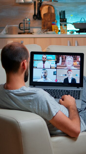 Maschio caucasico che parla con i colleghi durante la videoconferenza