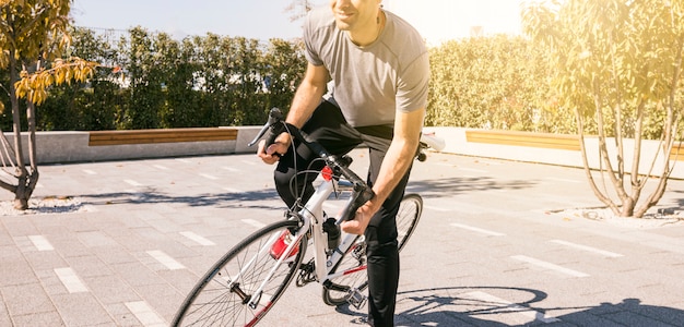 Maschio ciclista in sella a una bicicletta all&#39;aperto