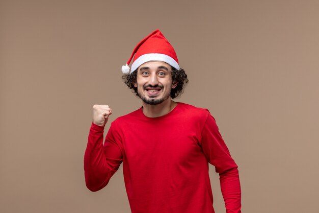 Maschio di vista frontale in rosso con l'espressione eccitata sul natale di emozione di festa del fondo marrone