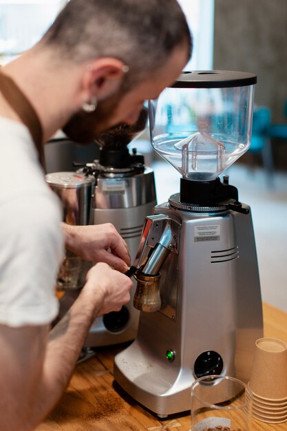 Maschio di vista laterale che prepara caffè