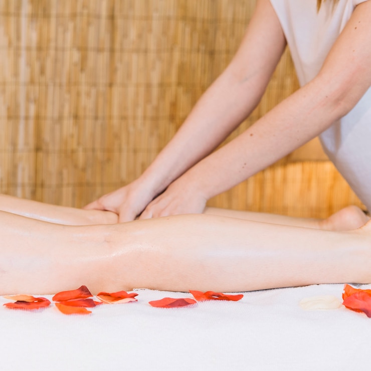 Foto gratuito massaggi il concetto con i fiori accanto alla donna