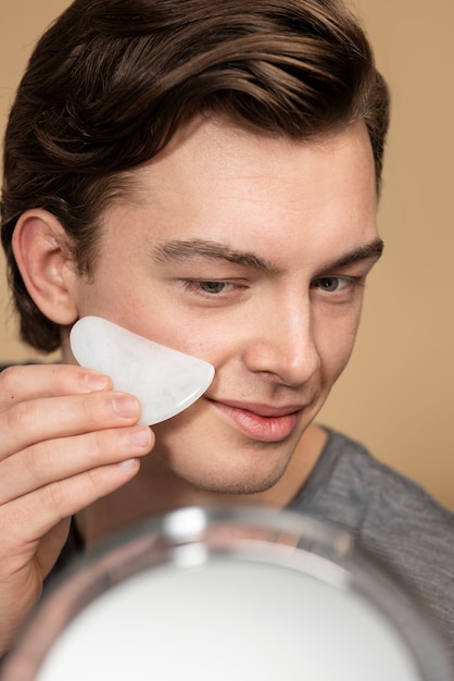 Massaggio del viso dell'uomo con gua sha