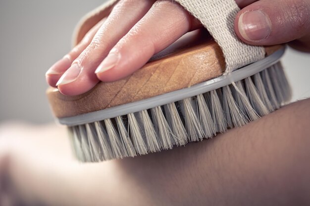 Massaggio delle mani femminili con una spazzola da massaggio