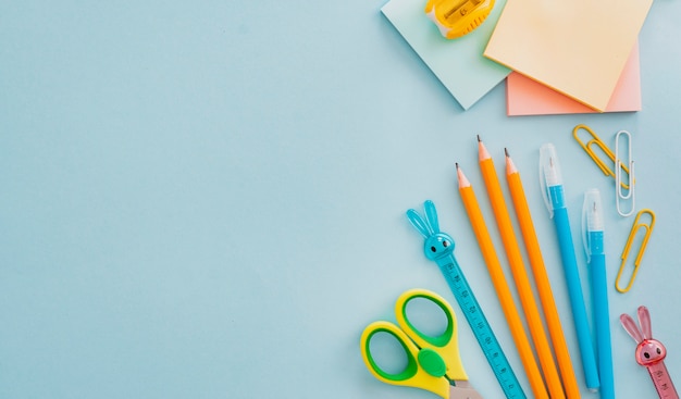 Materiale scolastico di cancelleria sul blu, di nuovo al concetto di scuola con copia spazio per il testo, piatto laici