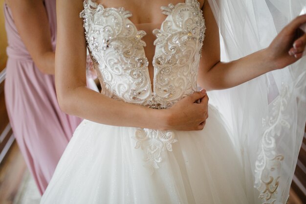 Mattina della sposa quando indossa un bellissimo vestito