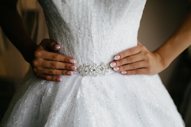 Mattina della sposa quando indossa un bellissimo vestito