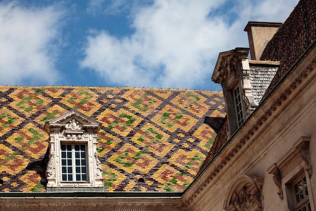 Mattonelle di tetto di ceramica tradizionali su un edificio governativo a Digione, Borgogna, Francia.