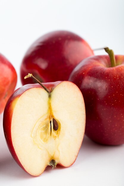 Maturo fresco succoso dolce delle mele rosse isolato sullo scrittorio bianco