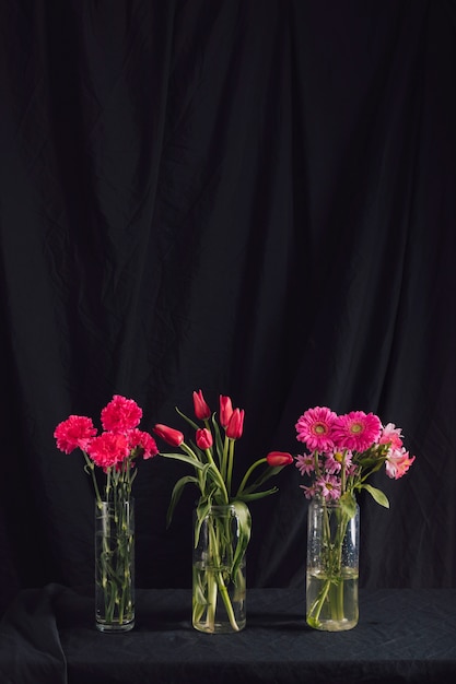 Mazzi di fiori rosa in vasi con acqua