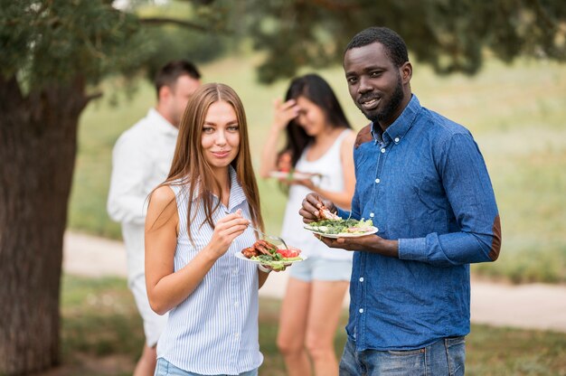 Mazzo di amici che godono del barbecue all'aperto