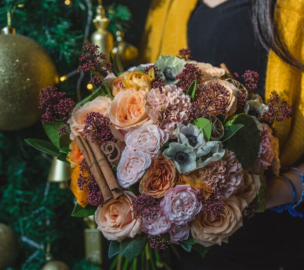 Mazzo di autunno inverno con fiori caldi e bastoncini di cannella