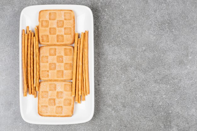 Mazzo di biscotti e salatini sulla piastra bianca