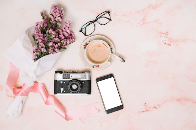 Mazzo di fiori con smartphone e tazza di caffè