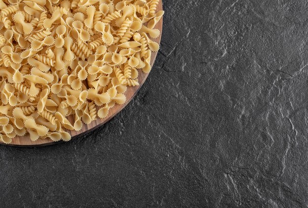 Mazzo di pasta varia sul piatto di legno. Foto di alta qualità