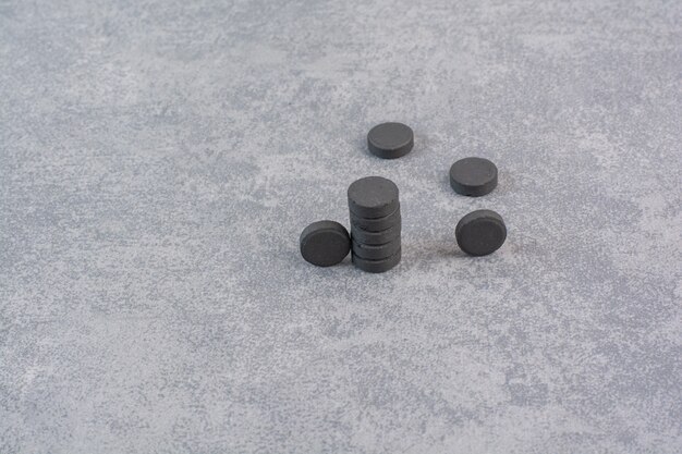 Mazzo di pillole nere sul tavolo di marmo.