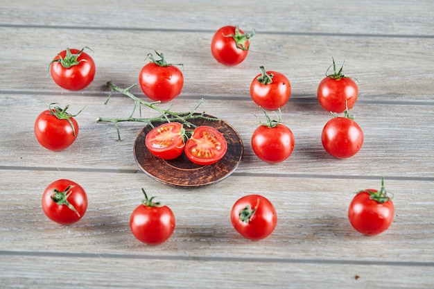 Mazzo di pomodori freschi succosi e fette di pomodoro sulla tavola di legno.