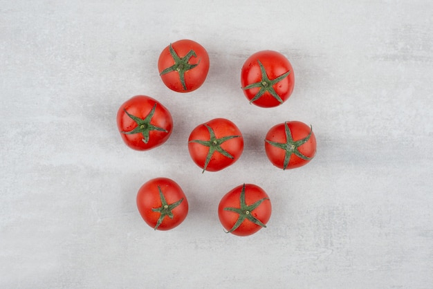 Mazzo di pomodori rossi sulla superficie bianca.