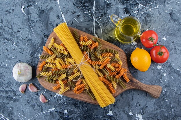 Mazzo di spaghetti crudi in corda con pasta e verdure multicolori.