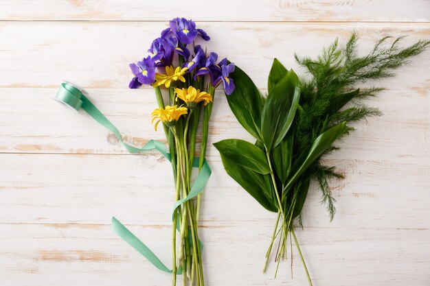 Mazzo di vista superiore dei fiori sulla tavola di legno