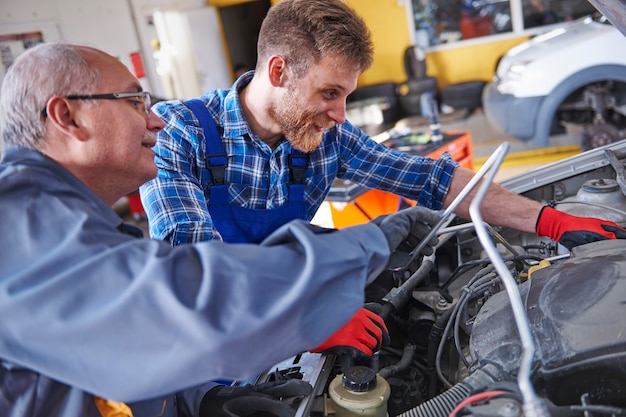 Meccanici che riparano un'auto in officina