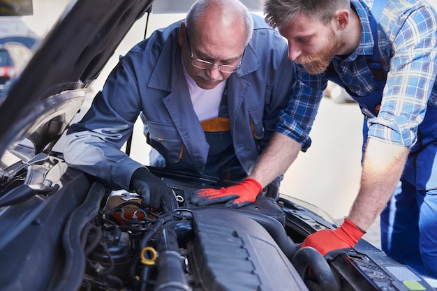 Meccanici che riparano un'auto in officina