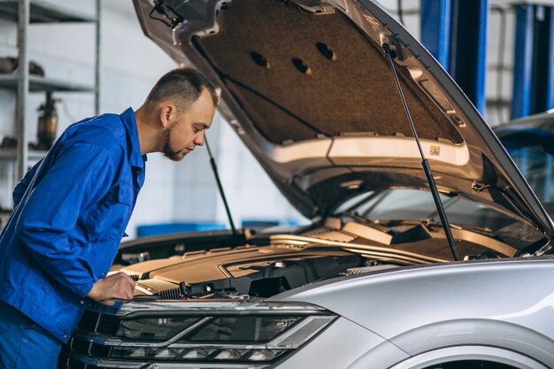 Meccanico auto che controlla il motore di automobile