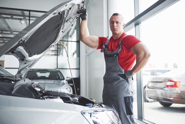 Meccanico auto che lavora in garage. Servizio di riparazione.