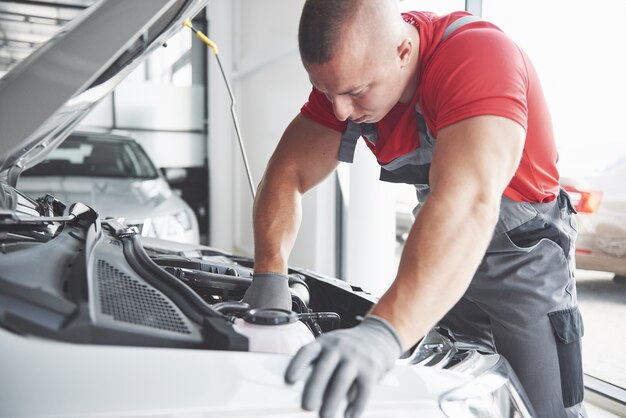 Meccanico auto che lavora in garage. Servizio di riparazione.