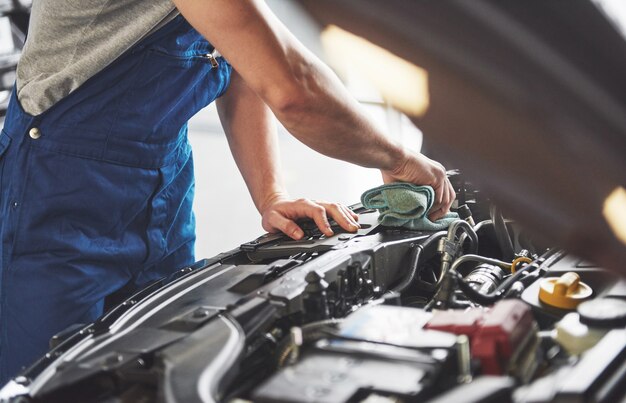 Meccanico auto che lavora in garage. Servizio di riparazione.